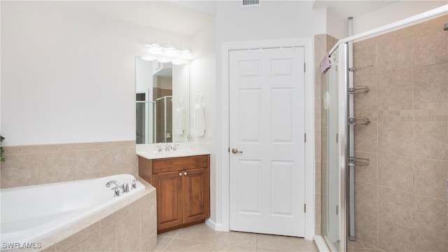 full bathroom featuring a stall shower, visible vents, tile patterned floors, a garden tub, and vanity