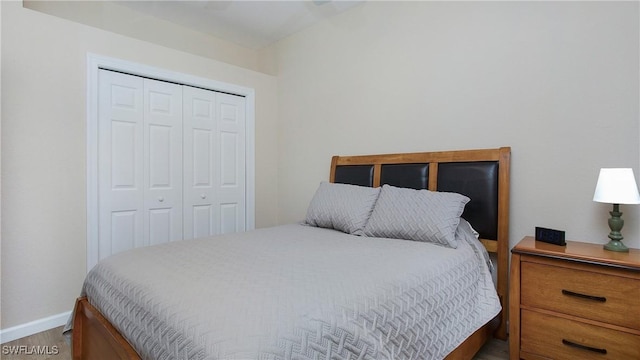 bedroom with baseboards, a closet, and wood finished floors