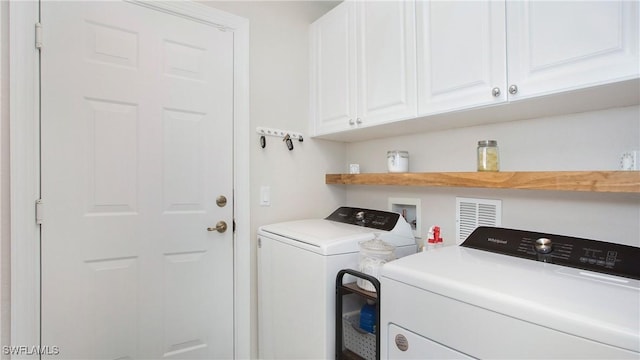 washroom featuring independent washer and dryer and cabinet space