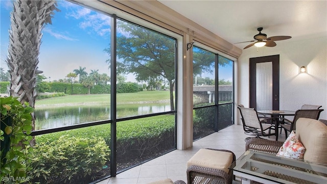 sunroom / solarium featuring a water view and ceiling fan