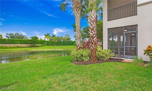 view of yard featuring a water view and a sunroom