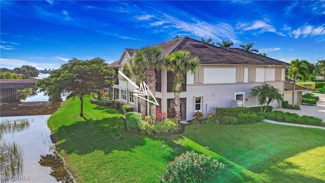 view of property exterior featuring a water view, a yard, and stucco siding