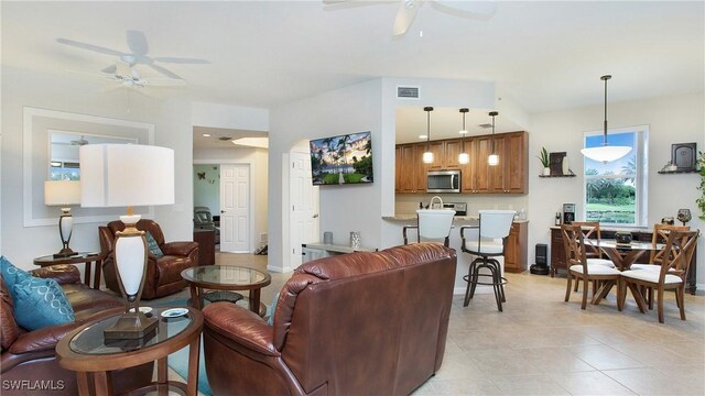 living room with ceiling fan, sink, and light tile patterned flooring