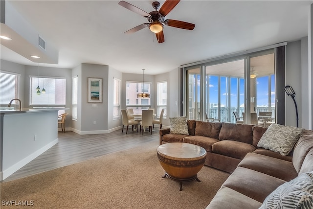 living room with sink, wood-type flooring, and ceiling fan