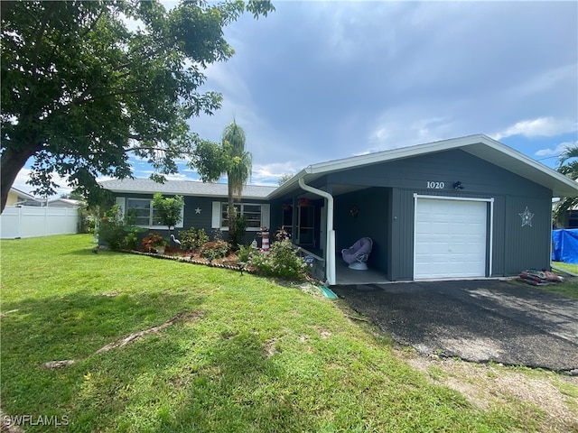 ranch-style house featuring a garage and a front lawn