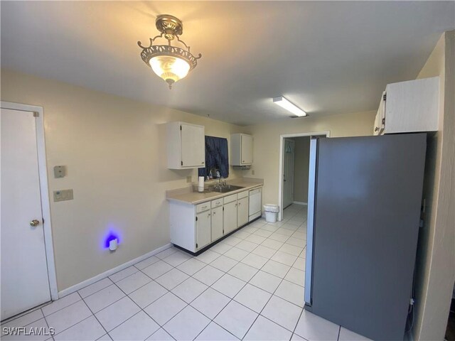 kitchen featuring white cabinets, white dishwasher, stainless steel fridge, light tile patterned floors, and sink