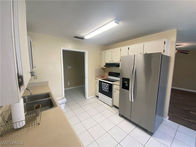 kitchen featuring light tile patterned flooring, white cabinets, stainless steel refrigerator with ice dispenser, white range with electric cooktop, and sink