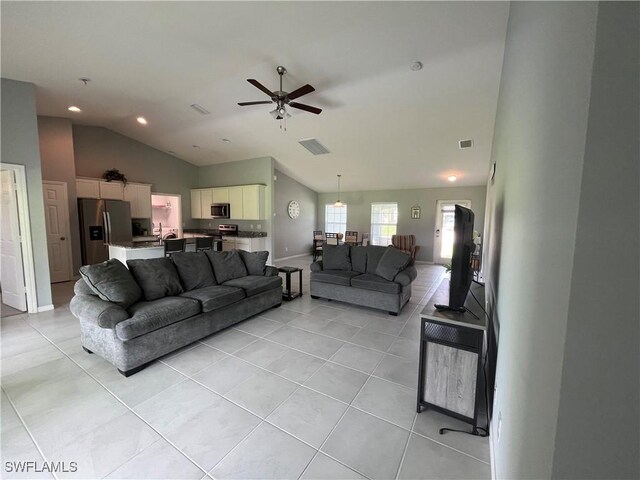 tiled living room with lofted ceiling and ceiling fan