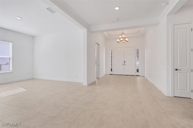 tiled entrance foyer featuring a tray ceiling, an inviting chandelier, and crown molding