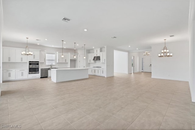 unfurnished living room featuring crown molding, a notable chandelier, and sink