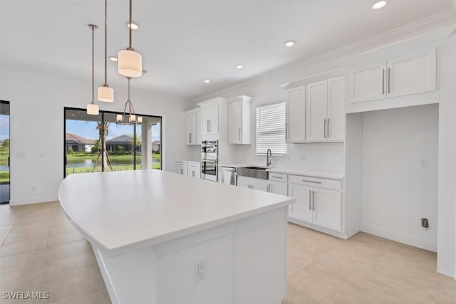 kitchen with plenty of natural light, hanging light fixtures, and white cabinetry