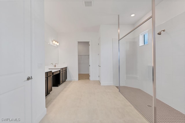 bathroom with a shower with shower door and vanity