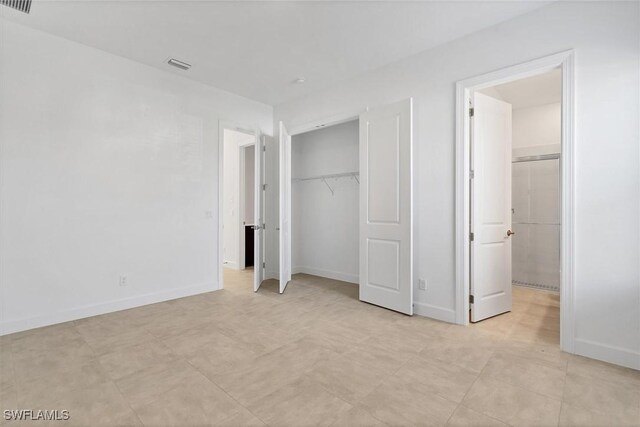 11902 Raggio Dr, Fort Myers, FL 33913 - unfurnished bedroom featuring a closet, ensuite bathroom, and baseboards