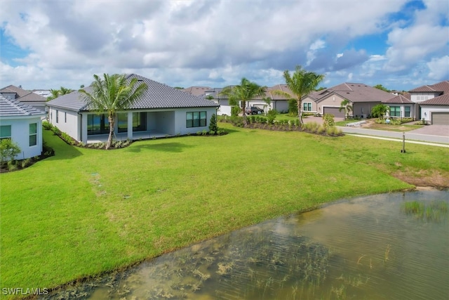 view of yard featuring a garage and a water view