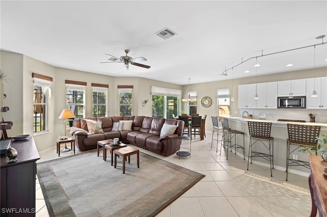 tiled living room featuring plenty of natural light and ceiling fan