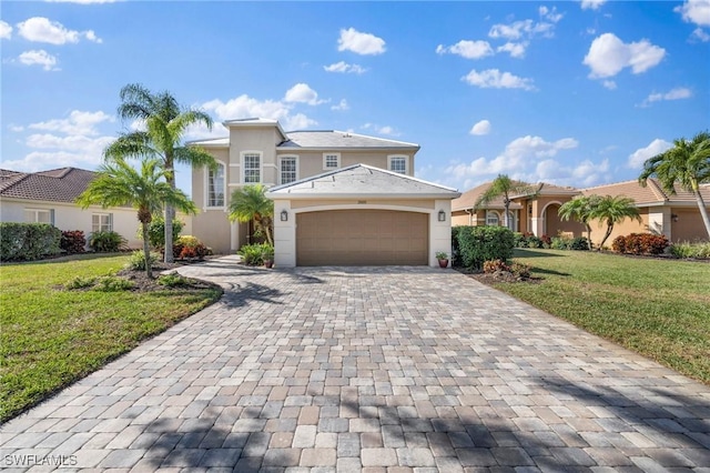 view of front facade featuring stucco siding, an attached garage, decorative driveway, and a front yard