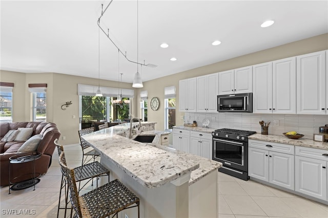 kitchen featuring appliances with stainless steel finishes, sink, decorative light fixtures, and white cabinets