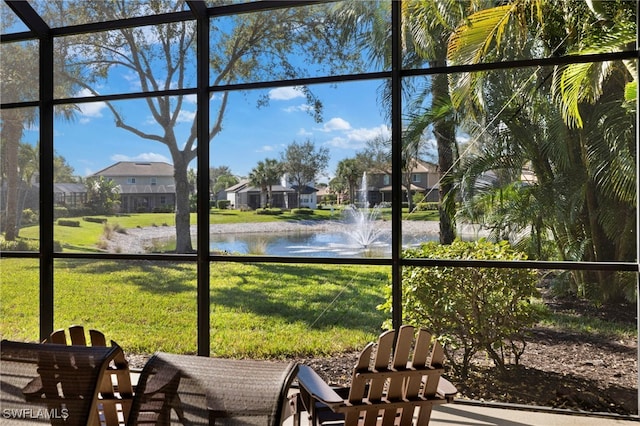 sunroom featuring a water view