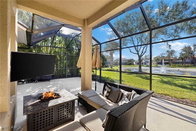 view of patio / terrace featuring a water view, an outdoor living space with a fire pit, and a lanai