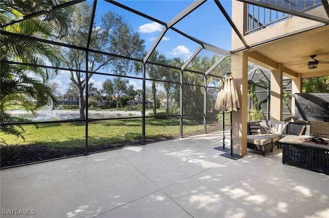 view of patio / terrace with a balcony, an outdoor hangout area, glass enclosure, and ceiling fan