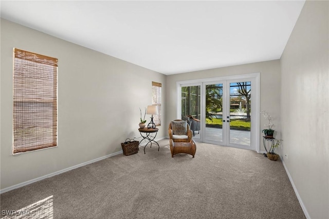 living area featuring french doors, carpet flooring, and baseboards