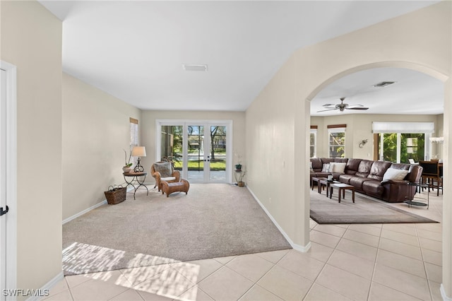 living area with ceiling fan, light tile patterned floors, and french doors