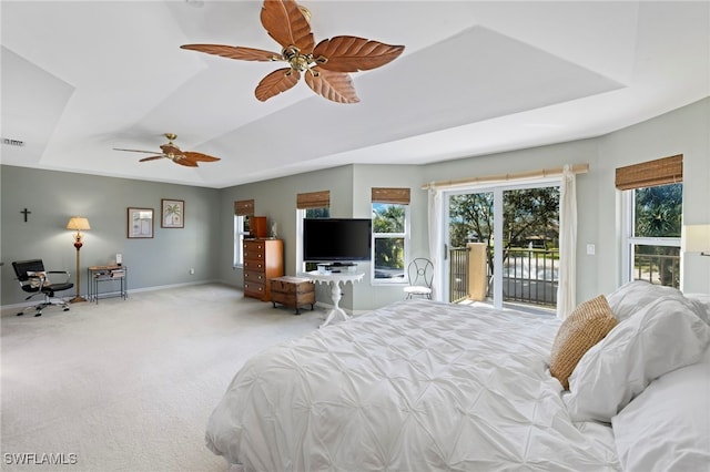 bedroom with light carpet, a tray ceiling, ceiling fan, and access to outside