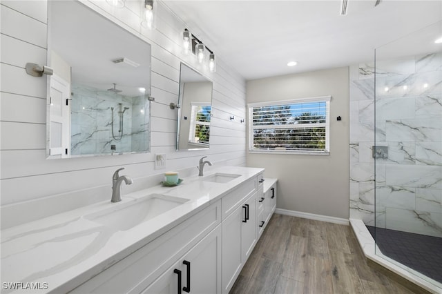 bathroom featuring vanity, wood-type flooring, and tiled shower