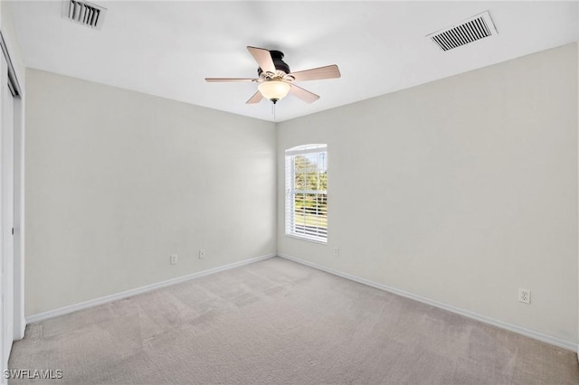 unfurnished room with visible vents, ceiling fan, and light carpet