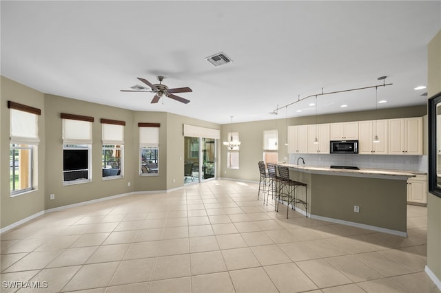 kitchen with backsplash, black microwave, visible vents, and a wealth of natural light