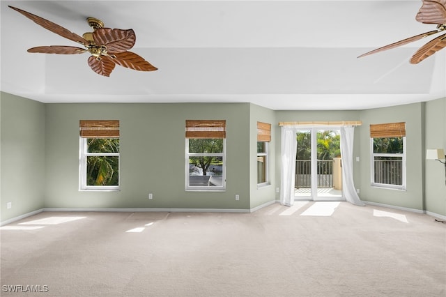 carpeted spare room featuring ceiling fan and baseboards