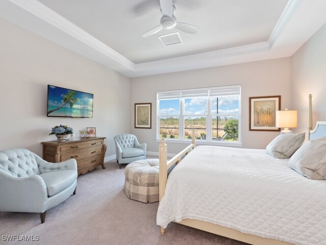 carpeted bedroom with ceiling fan, a raised ceiling, and crown molding