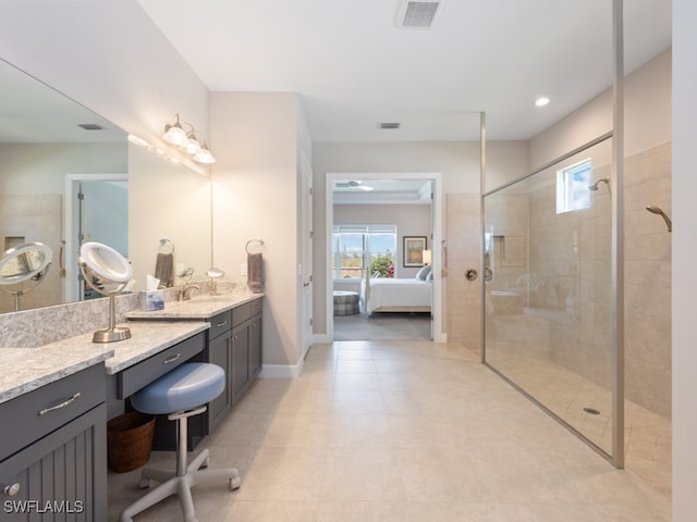 bathroom featuring a tile shower, vanity, and tile patterned floors