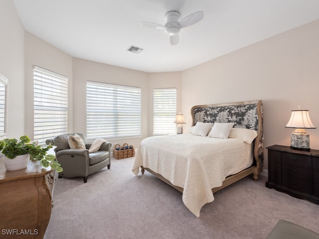 bedroom with light carpet, multiple windows, and ceiling fan