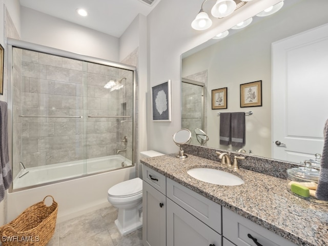 full bathroom with tile patterned flooring, bath / shower combo with glass door, vanity, and toilet