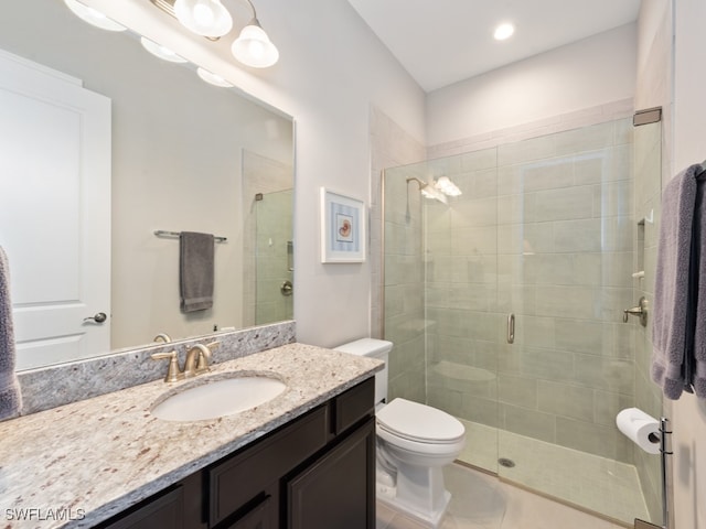 bathroom with vanity, tile patterned flooring, toilet, and a shower with door