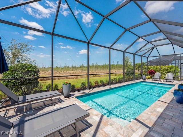 view of swimming pool featuring a lanai and a patio