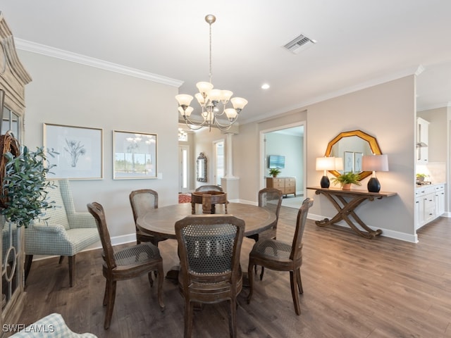 dining room featuring an inviting chandelier, ornamental molding, and dark hardwood / wood-style flooring