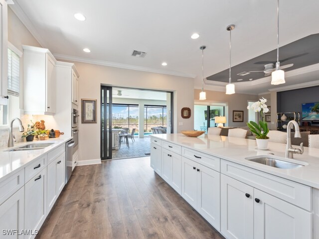 kitchen featuring white cabinets, ceiling fan, hanging light fixtures, and sink