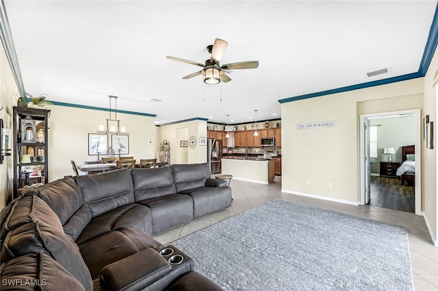 tiled living room with ceiling fan and crown molding