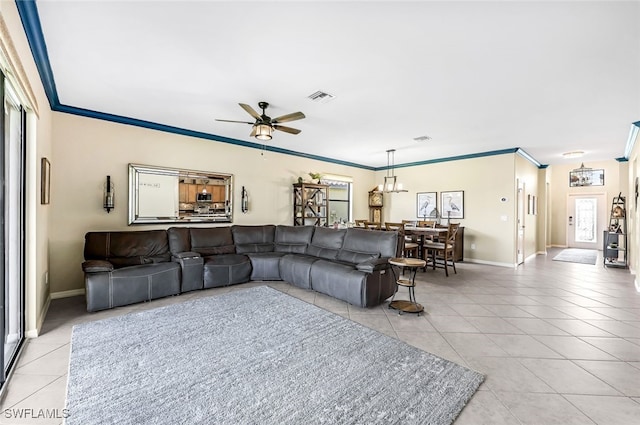 tiled living room featuring ceiling fan, crown molding, and a healthy amount of sunlight