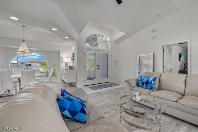 living room with french doors, high vaulted ceiling, and an inviting chandelier