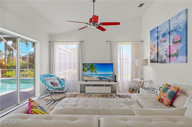 living room featuring lofted ceiling, ceiling fan, and a wealth of natural light