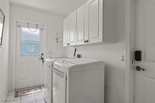 laundry area with light tile patterned floors, cabinets, and washer and dryer