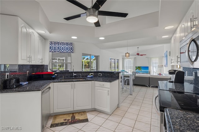 kitchen featuring dark stone countertops, white cabinets, and ceiling fan