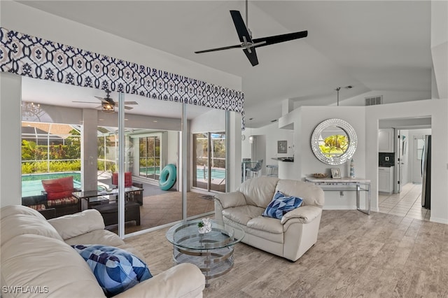 living room with light hardwood / wood-style flooring, ceiling fan, and vaulted ceiling