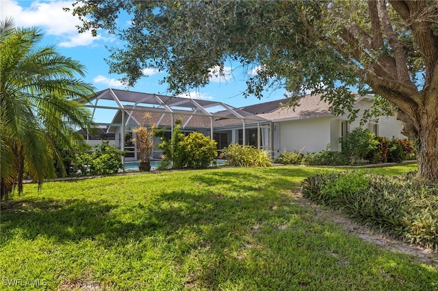 view of front of property with glass enclosure and a front yard