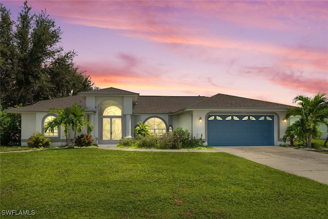 view of front facade featuring a garage and a lawn