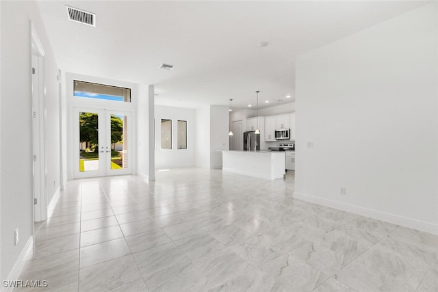 unfurnished living room featuring french doors