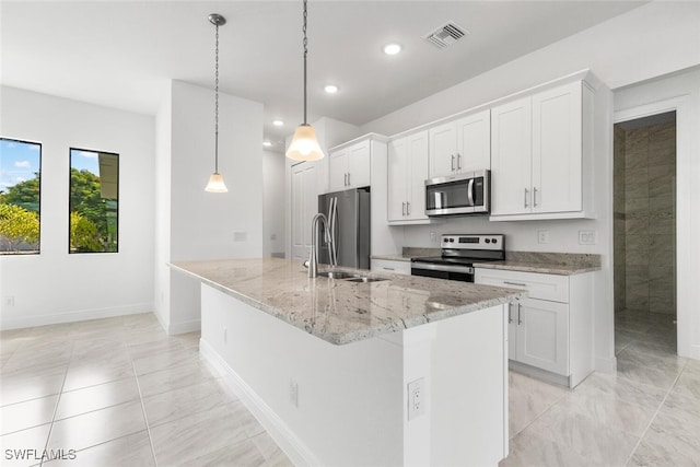 kitchen with white cabinets, an island with sink, appliances with stainless steel finishes, and hanging light fixtures